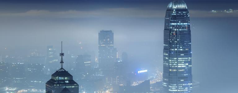 Mistige nachtelijke skyline met verlichting.