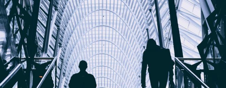 Two people looking at a glass ceiling.