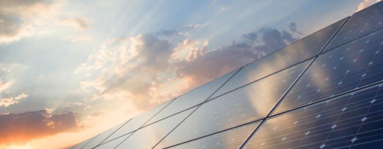 Zonnepanelen met wolken op de achtergrond.