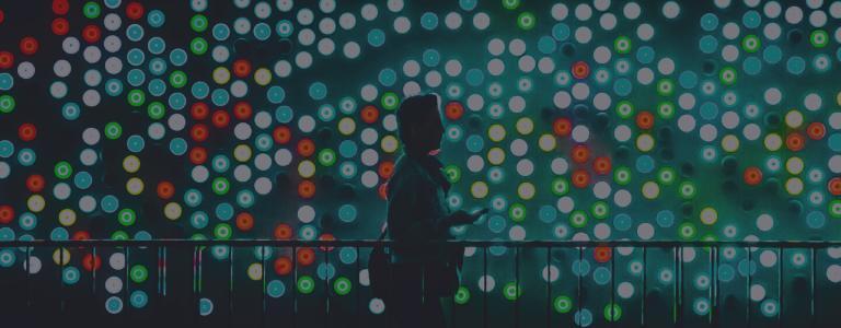 man standing in front of loads of different lights at night
